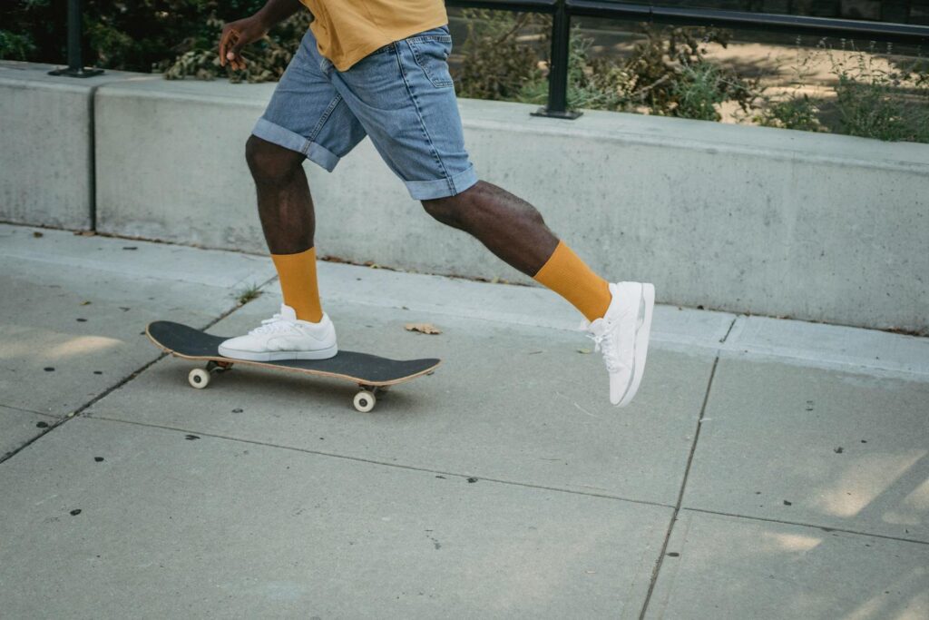 Low angle view of a man skateboarding on a sunny day, showcasing street style and sporty energy.